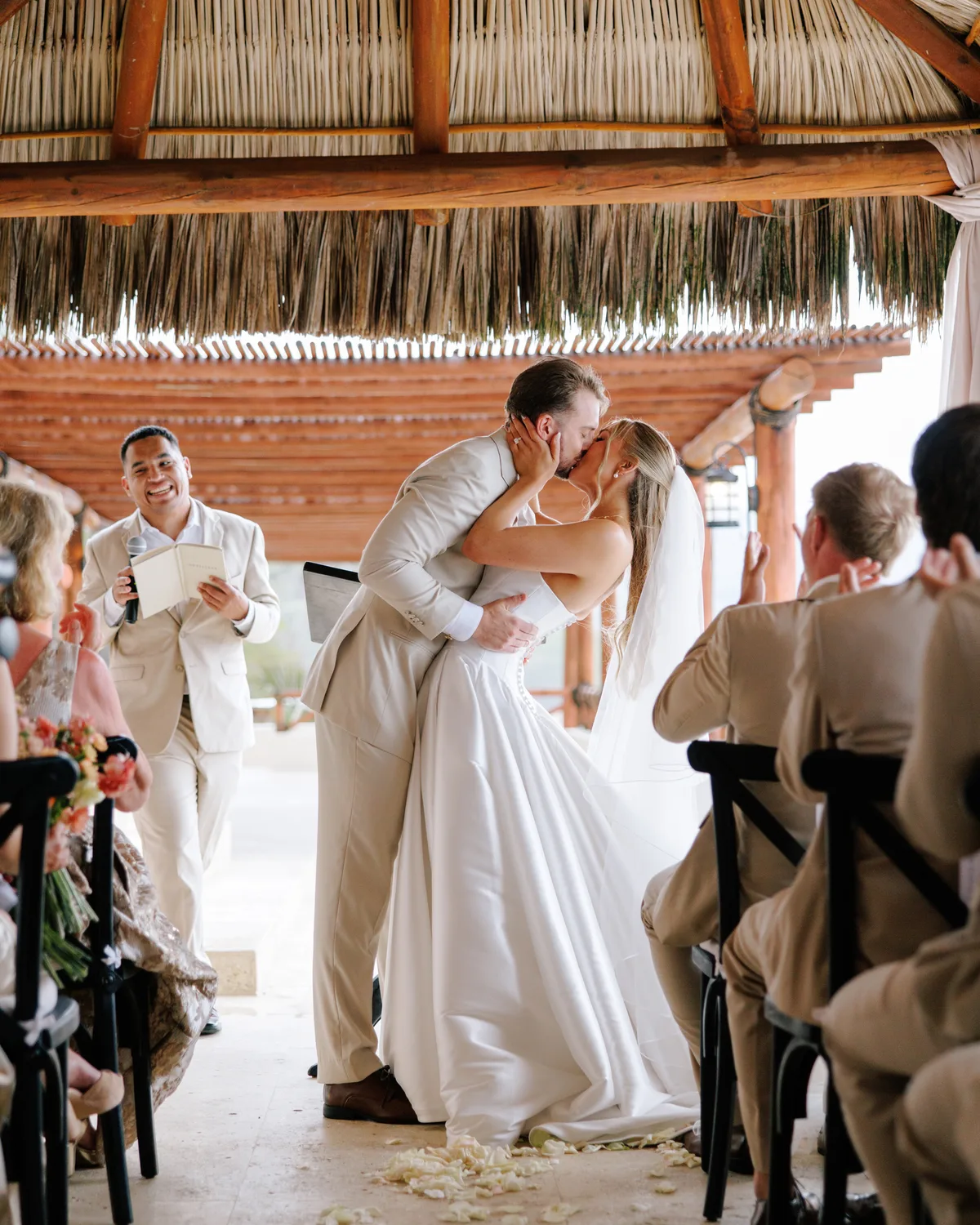 Ceremony kiss under the palapa at Hotel Playa Fiesta Puerto Vallarta by Evgenia Kostiaeva